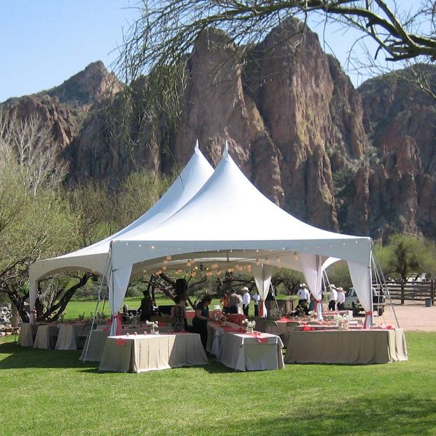 Outdoor wedding at the base of the superstition mountains with a unique catering table directing guests into the tents.